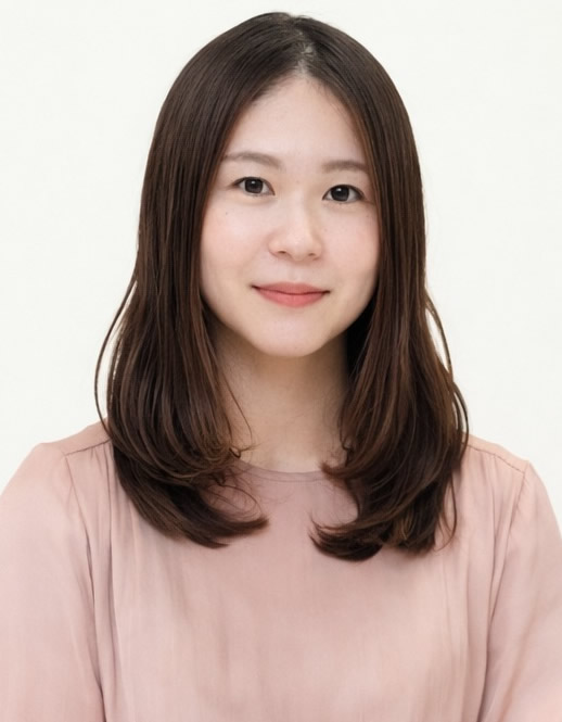 Portrait of a young Asian woman with shoulder-length brown hair, wearing a pink blouse, smiling softly against a light background.