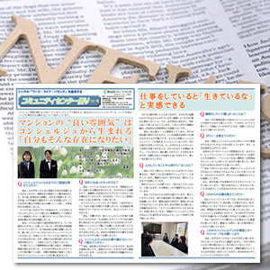 Japanese newspaper spread with multiple articles and photos on a desk, under a wooden 'News' sign.