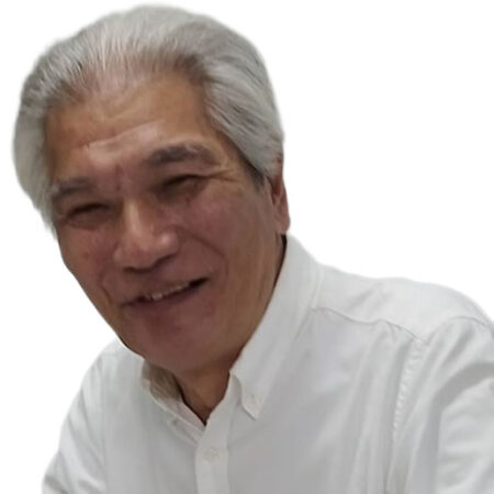 Portrait of an older man with silver hair and a friendly smile, wearing a white button-down shirt.